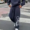 Conjunto de sudadera holgada con hombros caídos y pantalones de chándal de pierna ancha de estilo urbano americano en azul marino con letras florales, conjunto de dos piezas