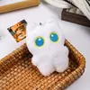 Lindo gato blanco y negro de ojos grandes sosteniendo un pequeño pez de peluche llavero colgante para mochila venta al por mayor