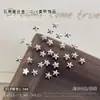 Decorações de arte de unha em liga metálica em formato de estrela de cinco pontas, um produto popular de exportação, com designs de estrelas de Natal prateadas metálicas e pretas, perfeitas para embelezamento de unhas e pequenos acessórios