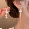 Aretes asimétricos de perlas con mariposa tachonada de diamantes y goteo de aceite de aguja plateada, aretes exquisitos y de alta gama para mujer, diseño único y de nicho