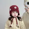 Gorro infantil otoño e invierno cálido engrosado a prueba de viento protección para las orejas bebé niña estilo coreano flor a prueba de viento para salir gorro de punto