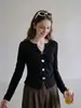 Camiseta negra de manga larga con cuello en V y decoración de botones para mujer, nuevo estilo otoño 2026, abertura irregular, top entallador
