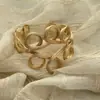 Brazalete abierto tejido de metal retorcido dorado brillante estilo antiguo vintage con un toque de alta gama