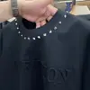 Nueva camiseta de moda de corte holgado con cuello redondo y manga corta con remaches y detalles en relieve para hombre, moda de primavera versátil casual calidad ropa de moda