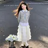 Elegante y dulce conjunto de dos piezas para niños mayores, con un top de diseño vanguardista de imitación de dos piezas combinado con una falda de encaje