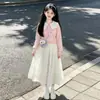 Atuendo Estilo Universitario 2026 para Niñas: Moderna Blusa de Muñeca con Cuello, Lazo de Dibujos Animados y Falda, Conjunto de Dos Piezas para Primavera y Otoño
