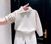 Conjunto de dos piezas para niño estilo coreano otoño e invierno 2026: suéter de punto beige con cuello, elegante, y pantalones blancos de pierna ancha para niños