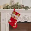 Nova decoração de Natal em vermelho e dourado com padrões brilhantes, apresentando enfeites pendurados de Papai Noel, boneco de neve e renas, meias de Natal de tecido, meias de Natal fofas de pelúcia