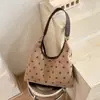 Colección de otoño 2026 transfronteriza: bolso de hombro de lunares casual de nicho, bolso tote moderno y versátil, bolso retro para debajo del brazo