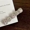 Instantaneamente cativante, este grampo de cabelo assimétrico com laço de cetim rosa é repleto de strass, transmitindo uma vibe luxuosa e fashion.