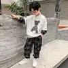 Conjunto de Outono para Meninos 2026 Versão Coreana Conjunto de Moletom Falso de Duas Peças com Manga Xadrez Infantil para Crianças Maiores com Design de Ursinho Conjunto Casual de Duas Peças