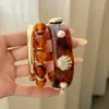 Pulsera Circular con Forma de Concha de Resina y Metal Chapado en Oro Ámbar, con un Toque de Lujo Ligero y de Alta Gama, Accesorio de Mano Simple y de Moda