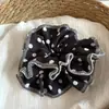Goma para el pelo de lunares gris lechoso, fresca y versátil, con un toque de alta gama, adecuada para coletas bajas en la nuca.