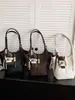Bolso tipo cubo de gama alta para mujer, nuevo estilo 2026, con dijes decorativos, un bolso de hombro ligero y lujoso, versátil para ir al trabajo y se puede llevar debajo del brazo