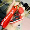 Dibujos animados creativos AJ simulación de zapatos deportivos coche mochila escolar hombres y mujeres PVC suave goma llavero colgante pequeño regalo lote