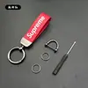 Llavero de coche con patrón de dibujos animados de marca creativa y moderna, colgante para motocicleta, correa de cuero y metal anti-pérdida, regalo
