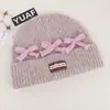Gorro de punto de estilo coreano inspirado en la dopamina con un lazo, diseñado para mujeres, que proporciona calor y protección para los oídos en otoño e invierno, y favorece el rostro; un sombrero pequeño y elegante para estudiantes