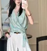 Top cruzado brillante de color menta que disimula y estiliza la figura, con un diseño único y una sensación suave y fluida de cinta.