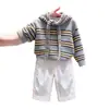 Ropa infantil coreana 2026 otoño e invierno nueva moda suéter de punto gris a rayas con corbata de lazo pantalones blancos anchos para niños modernos