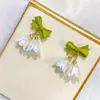 Coreia do Sul novos brincos de flor lírio-do-vale moda feminina versátil brincos de pérola com laço brincos elegantes e doces de sino