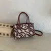 Bolsa de Mão Tendência Feminina 2026 Novo Estilo Versão Coreana Moda Textura de Alta Qualidade Estampada Pequena Quadrada Bolsa de Mão Vintage
