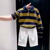 Ropa infantil estilo coreano 2026 colección otoño e invierno nueva: Suéter de punto con cuello polo a rayas azul marino y pantalones casuales blancos para niños