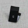 Etiqueta de tamaño de ropa negra Brocado doble corte ultra tela tejida de alta densidad arena fina etiqueta de tamaño plegable número etiqueta de número