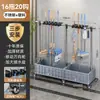 Soporte de piso para mopa y escoba de acero inoxidable con diseño elevado, que cuenta con una rejilla de drenaje para almacenar artículos de limpieza y organizar el baño