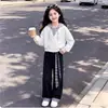 Conjunto versátil de dos piezas para niñas estilo preppy nuevo 2026 con top de manga larga con capucha y pantalones casuales a cuadros.