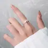 Anel em prata brilhante com laço de fita e detalhes em renda com pedras, com um design de renda vazada atmosférico, é um presente requintado para uma namorada.