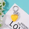 Nuevo llavero decorativo multicolor de resina con forma de corazón para llaves de coche, versátil y creativo.