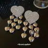 Brincos Europeus e Americanos de Agulha de Prata com Coração Cravejado de Diamantes e Borla 2026 Novo Estilo Estética Fria Personalidade Tarraxas de Orelha Nicho Toque de Luxo Ornamentos de Orelha