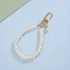 Llavero de correa de teléfono de perlas estilo Chanel para niñas con lazo en forma de corazón, flor y colgante de metal, accesorio para bolso