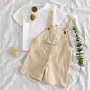 Comercio exterior ropa para niños conjunto de verano para bebé: Camiseta de manga corta con cuello redondo de color liso + Peto a rayas con botones de imitación de veta de madera, conjunto de dos piezas