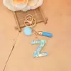 Novo design transfronteiriço: Chaveiro de letra brilhante e com lantejoulas, com um pompom rosa e franja, perfeito para bolsas de meninas e como pingente de chave