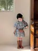 2026 Nuevo Estilo de Verano Estilo Coreano Ropa Infantil, Traje de Estilo Preppy para Niñas, Camisa a Cuadros, Falda de Botones Florales, Conjunto de Dos Piezas