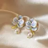 Pendientes de perlas con forma de flor de aguja de plata, nuevos diseños de estilo coreano de nicho, ligeros, lujosos, de alta gama, elegantes y combinables.
