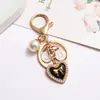 Nuevo Estilo Llavero Colgante Inspirado en Chanel Colgante para Funda Protectora de Auriculares Colgante de Corazón de Perla Joyería Colgante para Manija de Puerta