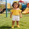 Conjunto de dos piezas de ropa infantil moderna con pantalones cortos vaqueros para niñas, top rosa con hombros descubiertos y pantalones cortos blancos.