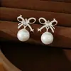 Aretes de plata con cierre de mariposa, con zirconia y moño de perlas, aretes dulces y elegantes versátiles, sensación de lujo ligero y alta gama, venta al por mayor