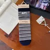 Calcetines retro a rayas hasta la pantorrilla estilo japonés para mujer, calcetines de algodón para otoño e invierno estilo coreano con etiquetas de tela de letras, calcetines apilados sin costuras en bloques de color