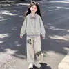 Nueva colección de otoño y primavera: Conjunto moderno de dos piezas para niñas, con un diseño de imitación de dos piezas con un top de patchwork y pantalones casuales de estilo retro.