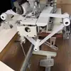Nueva máquina de coser plana multineedle para cinturas elásticas, con un dispositivo de dos ruedas para estirar y ensanchar la cintura elástica, un modelo versátil