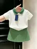 Conjunto de verano 2026 para niña estilo coreano: top blanco de punto trenzado con cuello polo de manga corta y falda plisada verde para niña pequeña