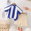 Versión coreana del nuevo conjunto de moda occidental de verano para bebé, camiseta de manga corta con estampado vertical de dibujos animados y pantalones cortos casuales, Directo de Fábrica