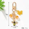 Bestseller transfronterizo: Llavero de aleación con recubrimiento de esmalte con diseño de abeja y panal incrustado con diamantes, llavero de dibujos animados, funda para auriculares, accesorio para bolso