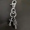 Nueva colección de llaveros con doble colgante featuring cruz, ancla, espada en forma de corazón y broche de langosta, elegantes y únicos