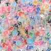 Paquete de 100 cuentas acrílicas con alfabeto oblatas, de color transparente, para manualidades.