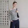 O novo top de lyocell para o início do outono apresenta um design listrado de um ombro só, mangas compridas e uma cintura ajustada que acentua a silhueta.