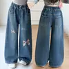 Pantalones infantiles transfronterizos otoño 2026 nuevo estilo jeans holgados para niños niños grandes modernos estampados lavados de pierna ancha